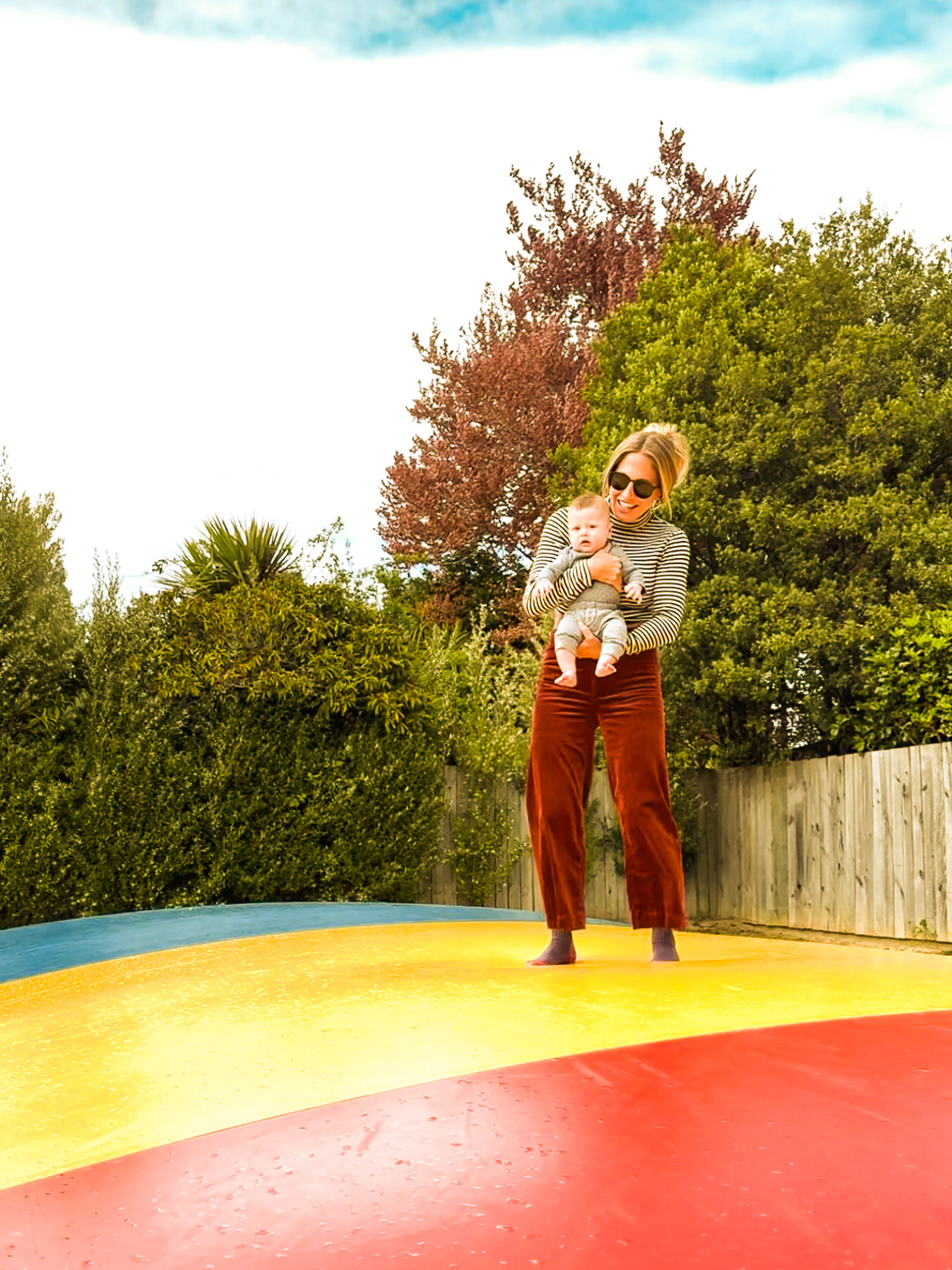 Mom and Infant jumping on Bouncing Pillows at Te Anau Holiday Park in Te Anau, South Island, New Zealand