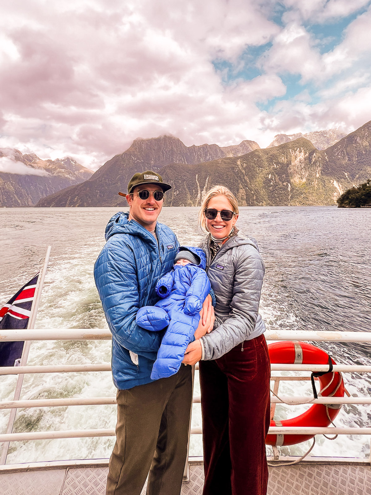 Traveling to New Zealand with a Baby: Parents holding baby on a Boat in Milford Sound, New Zealand