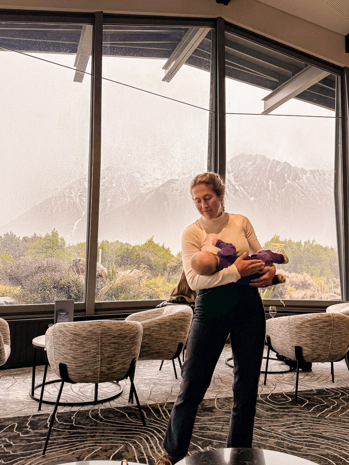 Mom holding infant inside The Hermitage Hotel in Mt. Cook, South Island, New Zealand