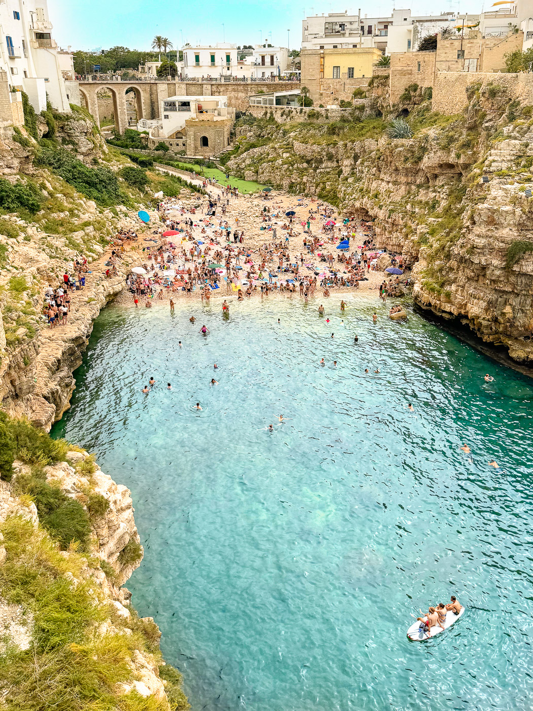 Ultimate Puglia Vacation Guide: View of Lama Monachile Beach in Polignano A Mare, Puglia, Italy from the cliffs above