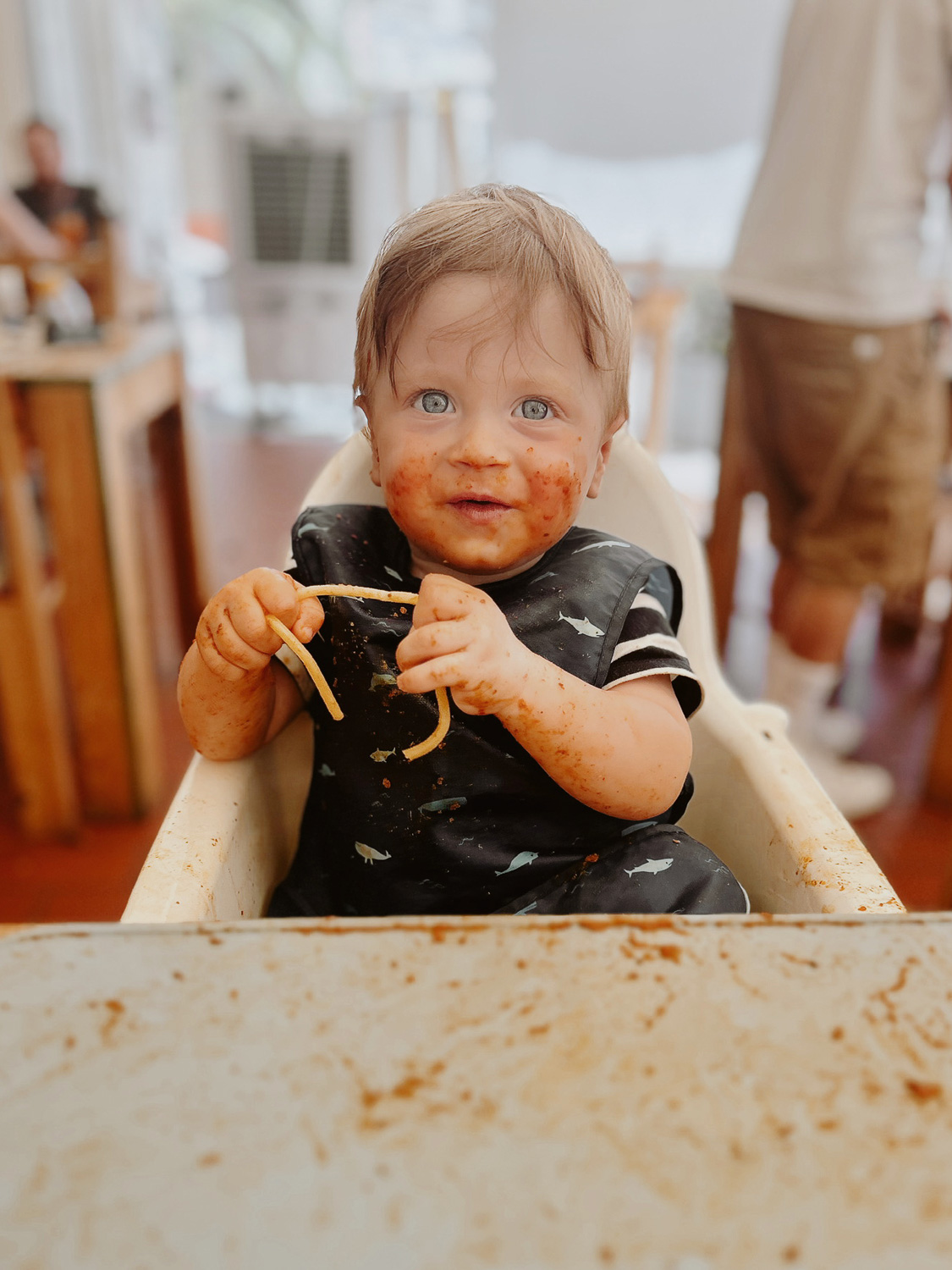 Essential Packing List for Traveling to Europe with a Baby: Baby eating spaghetti with a wipe clean bib and placemat in Monopoli, Puglia, Italy