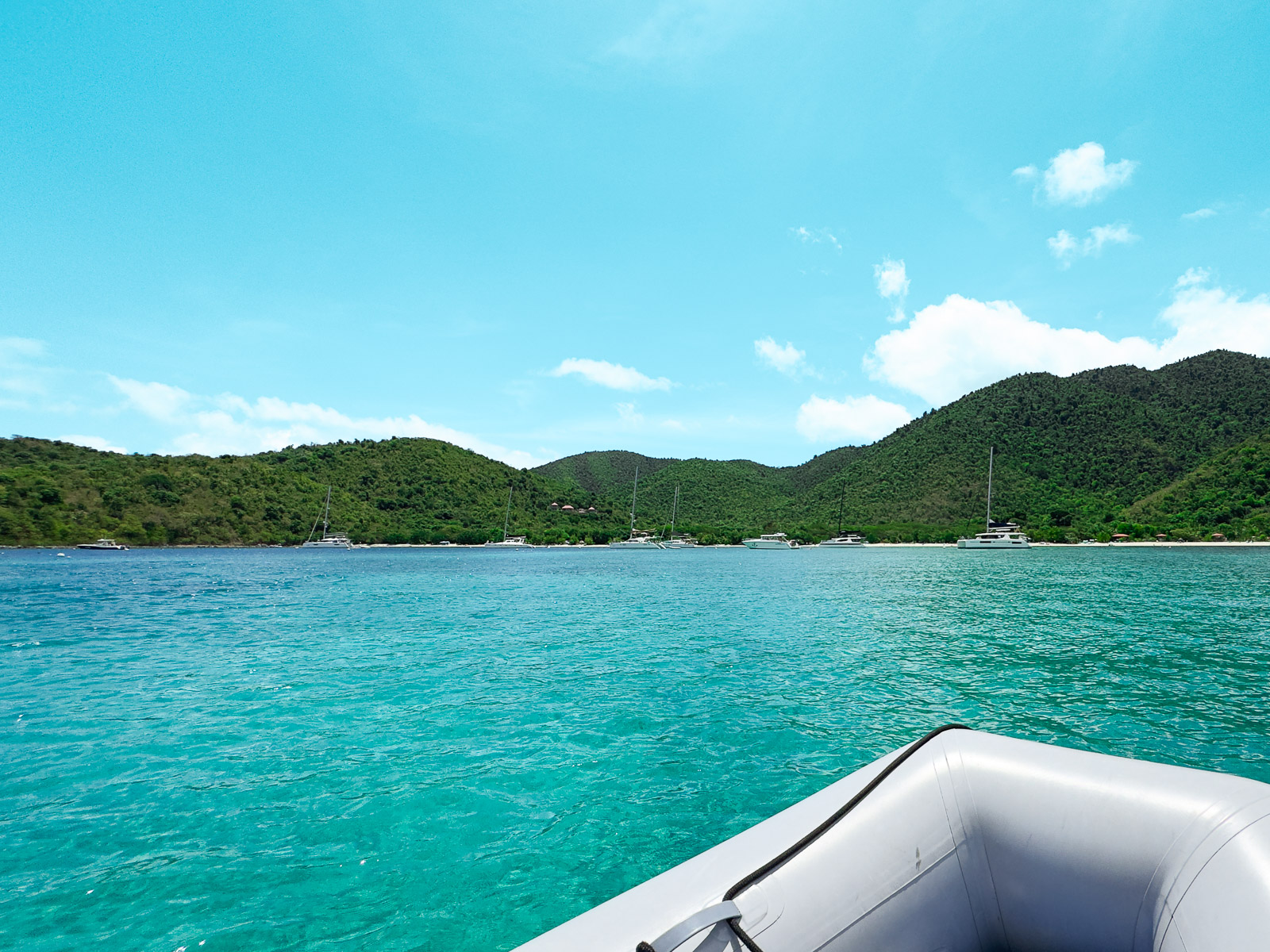 Complete Guide to Small Boat, Dinghy, Rentals in St. John USVI: View of the shore and anchored sailboats from a dinghy in Maho Bay St. John, USVI
