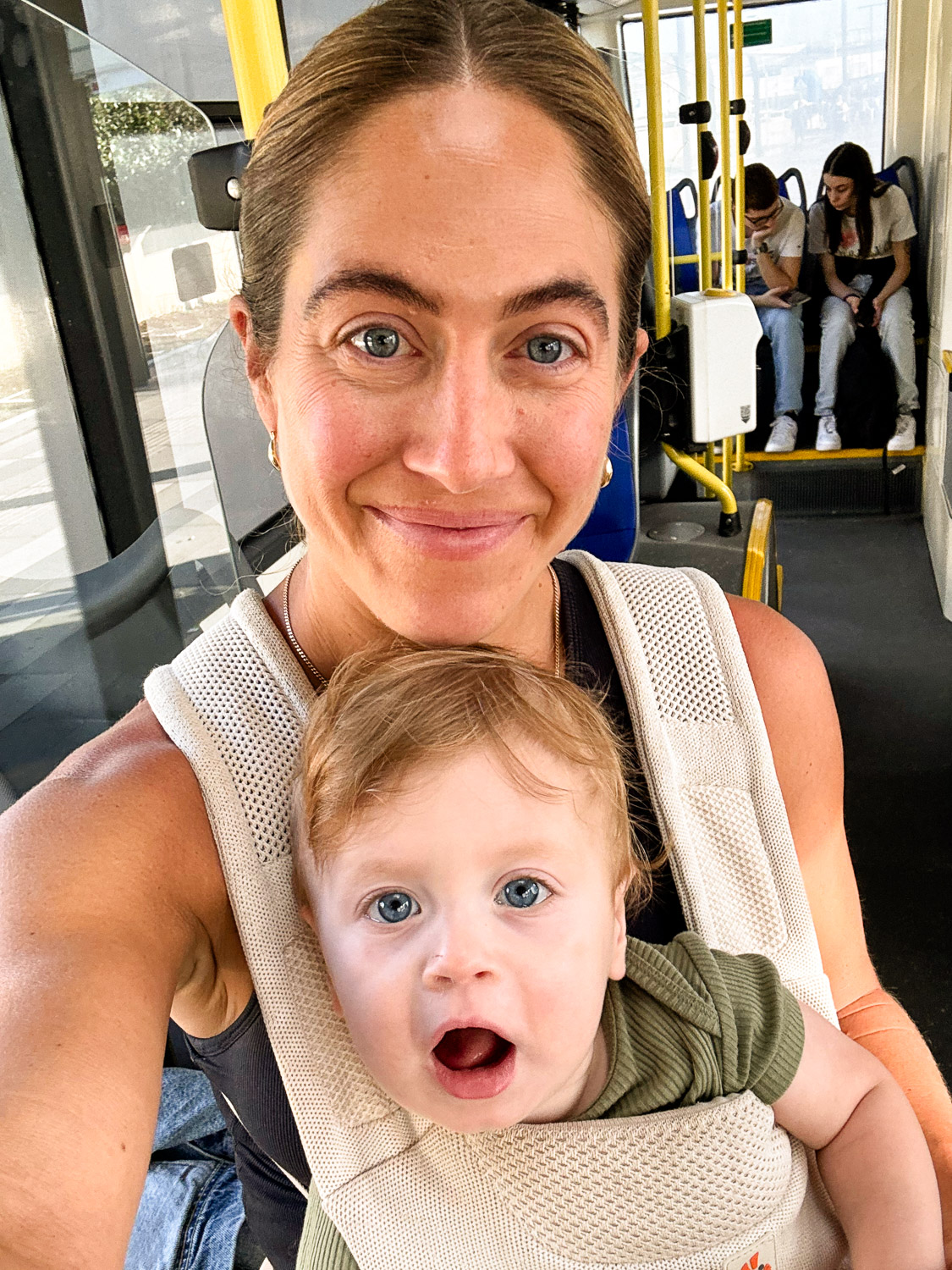 Essential Packing List for Traveling to Europe with a Baby: Mom on Bus Wearing Baby in a Baby Carrier