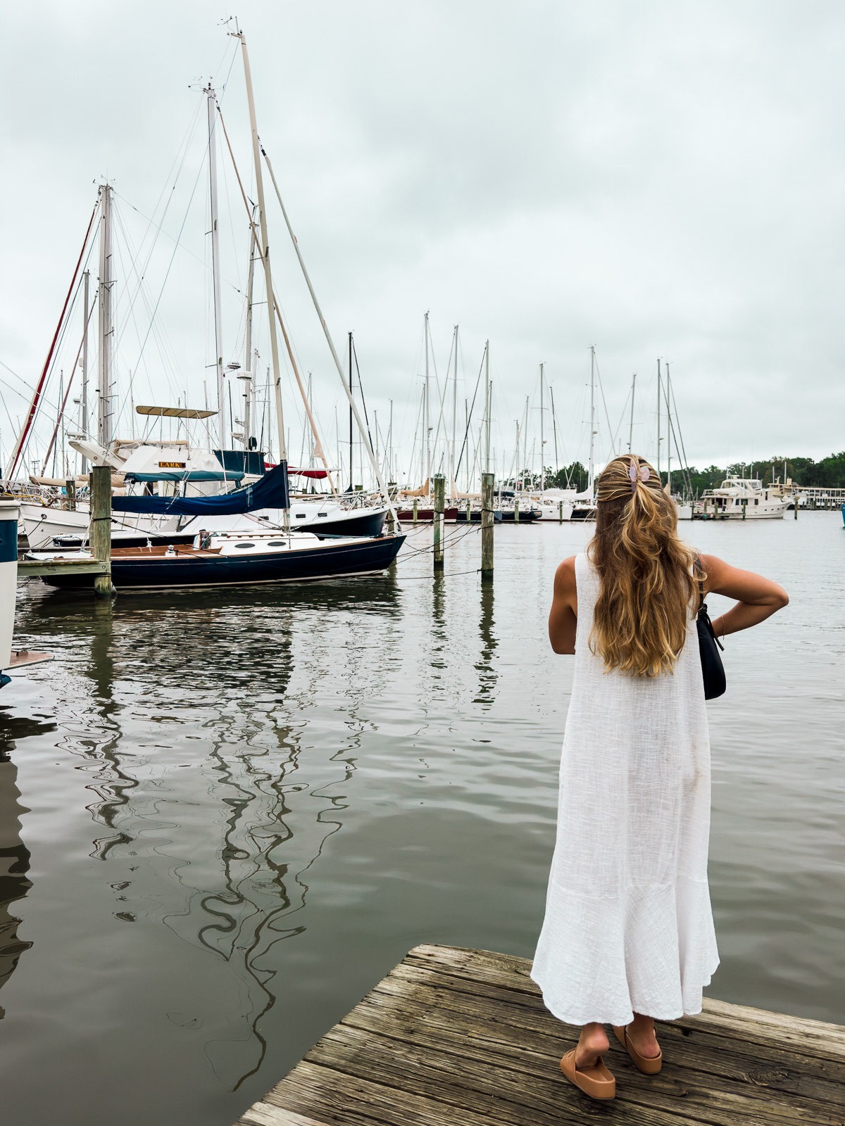 9 Must-Do Activities for the Perfect Weekend in Annapolis, Maryland: Woman standing at end of a dock in Eastport, Annapolis looking at sailboats in the harbor