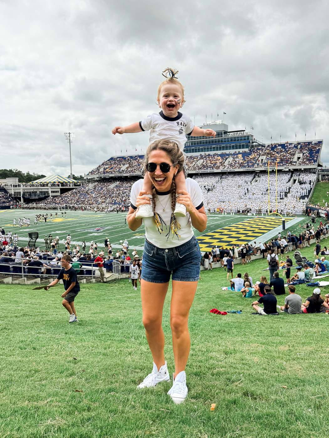 9 Must-Do Activities for the Perfect Weekend in Annapolis, Maryland: Mom and Baby posing for a photo on the endzone hill in front of the football field during a Navy Football game