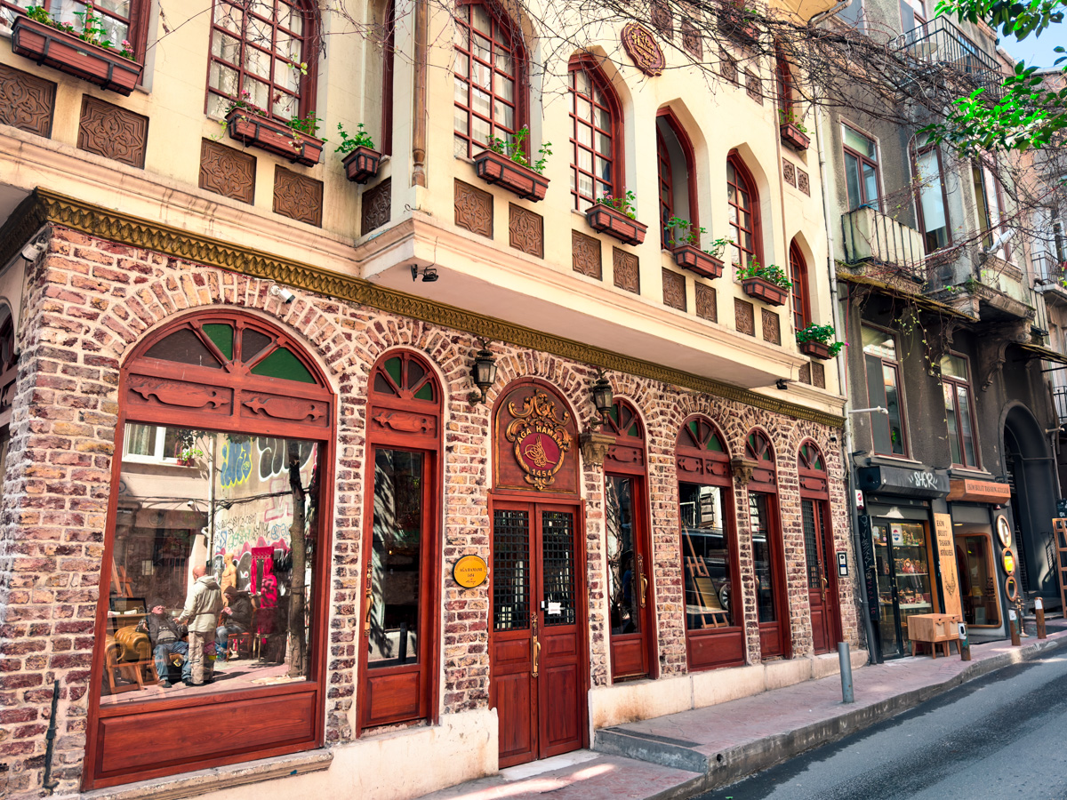11 Best, Most Unique Things to Do in Istanbul, Turkey: The facade of Aga Hamami Turkish Bath in Istanbul Turkey with arched doorway and window and planter boxes hanging from window ledges